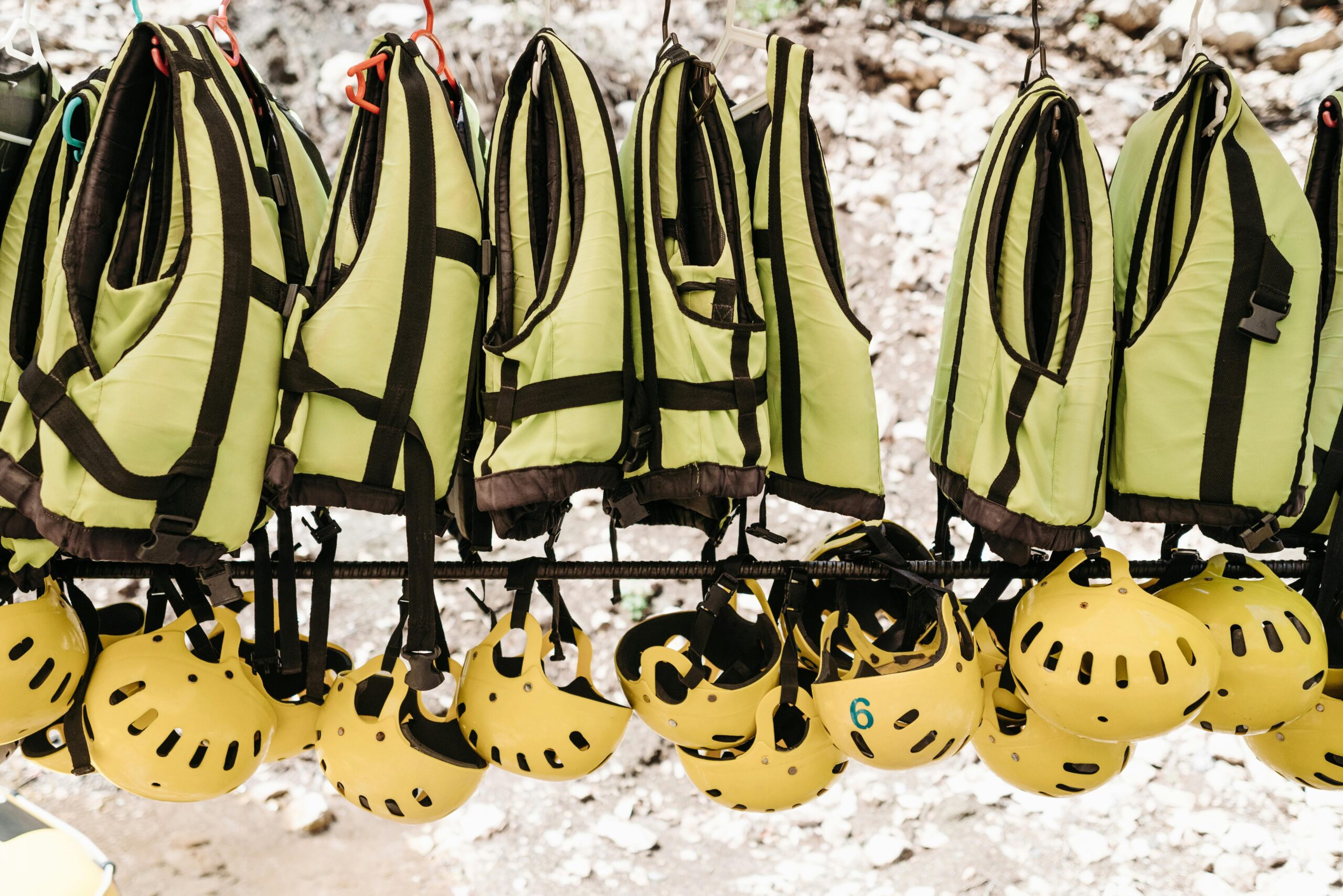 Hanging safety vests and helmets for outdoor adventure activities.